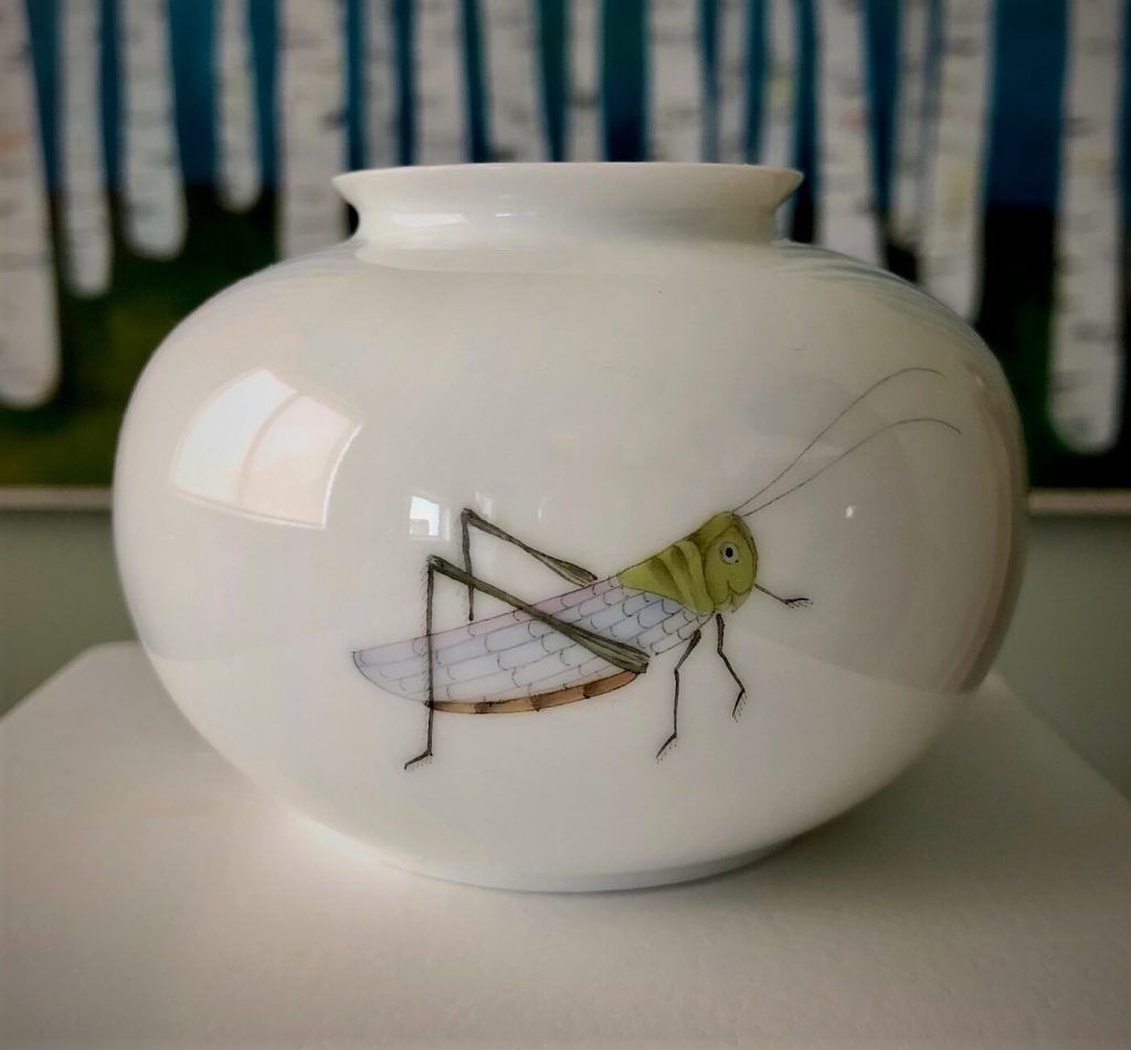 Small white Chinese porcelain vase featuring a grasshopper. 