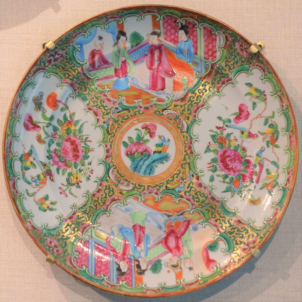 A "famille rose" Chinese porcelain plate showing a center medallion and scenes of Chinese people and gardens. 