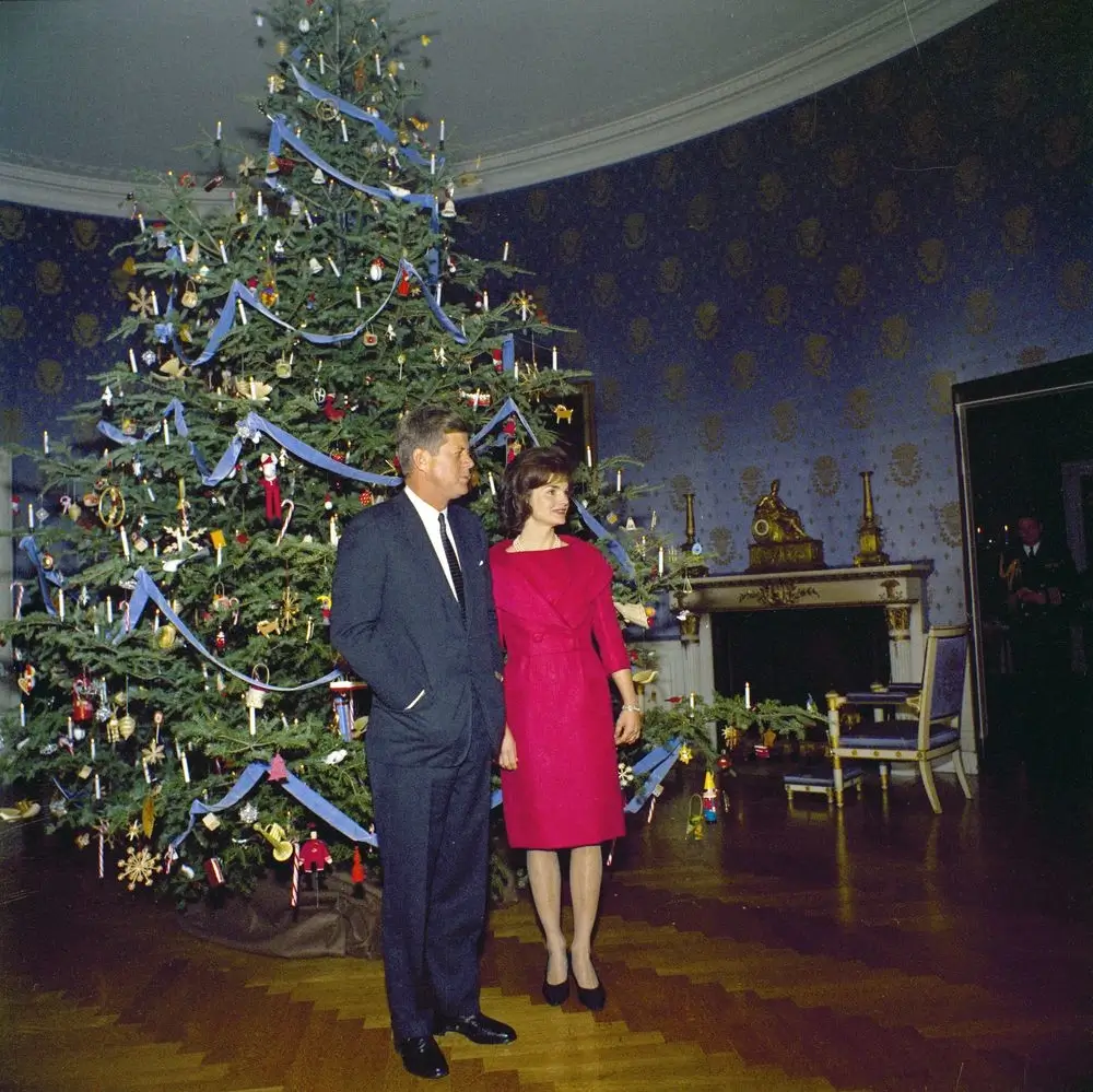JFK and Jaqueline Kennedy stand in front of the 1961 Nutcracker-themed White House Christmas tree. 