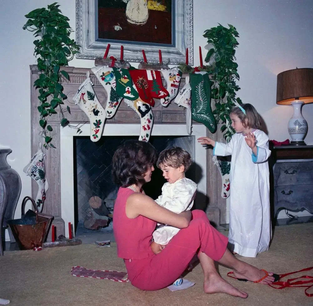 Jackie Kennedy embraces son JFK Jr. while Caroline stands by the fireplace on Christmas Day 1962.