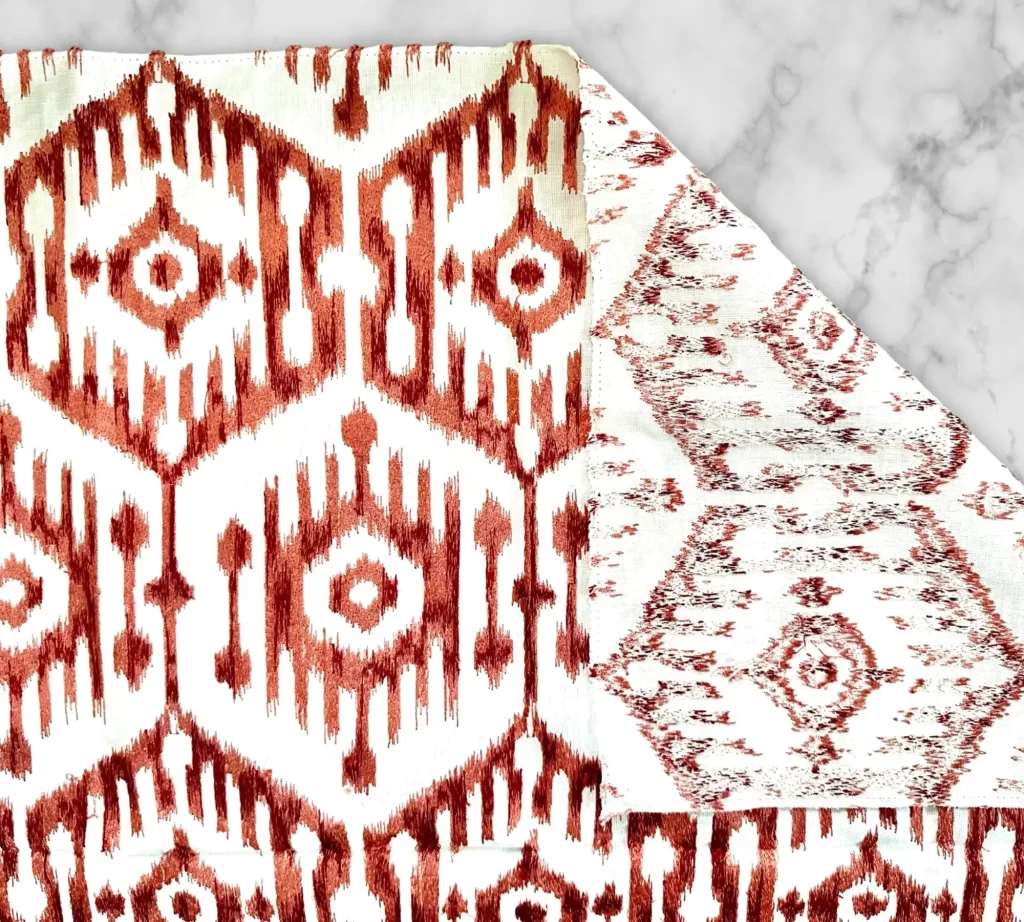 An example of an interior design fabric featuring a silk embroidered ikat pattern.