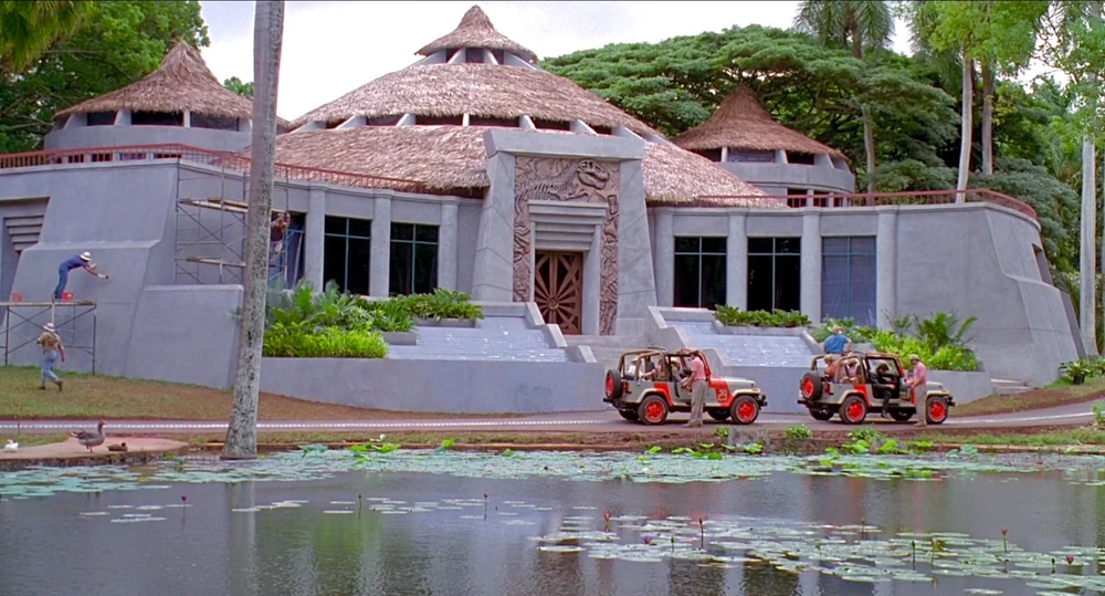 The facade of the Jurassic Park Visitor Center as John Hammond's guests arrive and disembark the jeeps. 