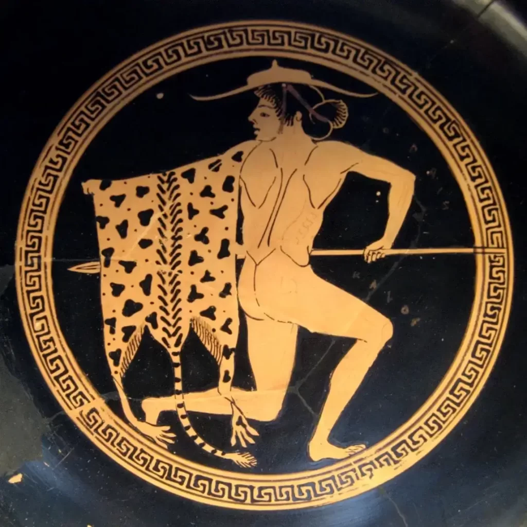 Red figure tondo on a Greek kylix featuring a youth carrying a leopard skin.