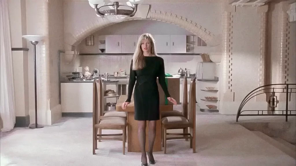 Vicki Vale stands in the dining area of her luxurious Gotham City apartment. 